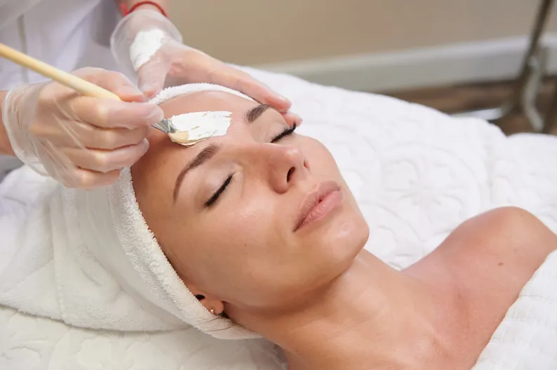 Der Dermatokosmetologe trägt eine feuchtigkeitsspendende Maske auf 