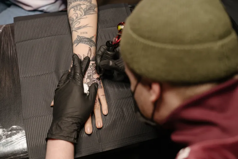 A tattoo artist with his client